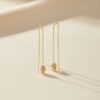Bijoux e-commerce : Boucles d'oreilles fines dorées 6 cm portées sur lobe