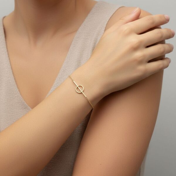 Bracelet cercle plaqué or 18 kt porté au poignet, style élégant et minimaliste