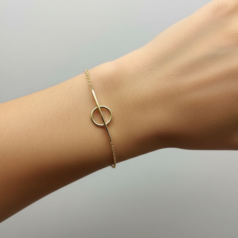 Bracelet cercle plaqué or 18 kt porté au poignet, style élégant et minimaliste