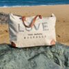 sac de plage XXL brodé LOVE en toile upcyclée posé sur la plage de Hossegor