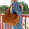 Grand sac hobo en daim camel, porté à l’épaule avec élégance