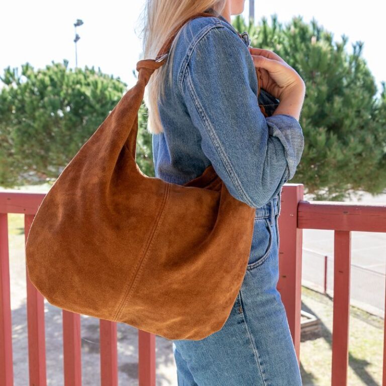 Grand sac hobo en daim camel, porté à l’épaule avec élégance