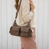 Sac en cuir suède multipoche Sienna porté à l’épaule, style chic et décontracté couleur taupe